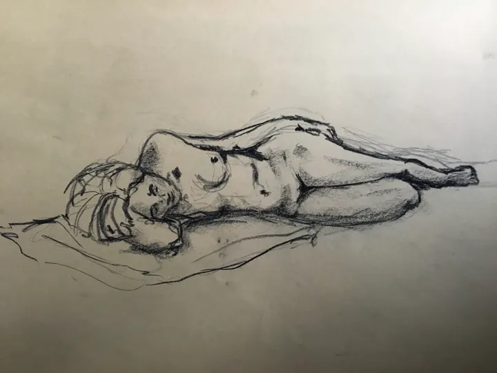 Charcoal life drawing of a nude figure lying on their side