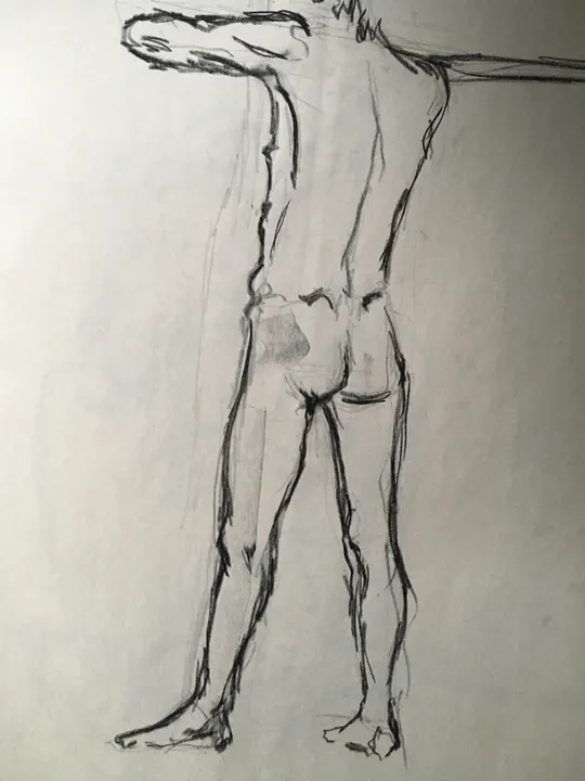 Charcoal life drawing of a standing nude figure, seen from behind with one arm outstretched