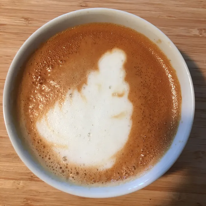 A big white blob of foam filling most of a white cup