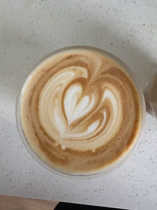 Overhead view of a latte with a broad, slightly lopsided heart