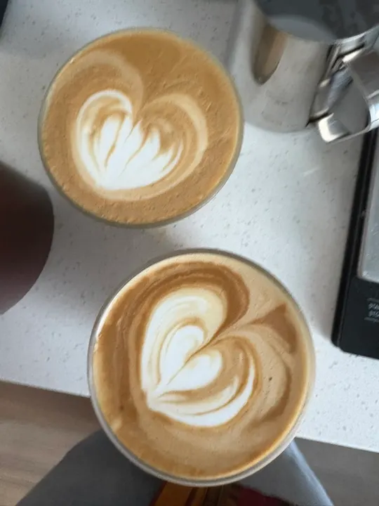 Two lattes, each with a layered heart