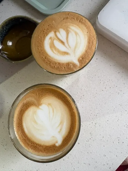 Two lattes on the counter, each with a rosetta