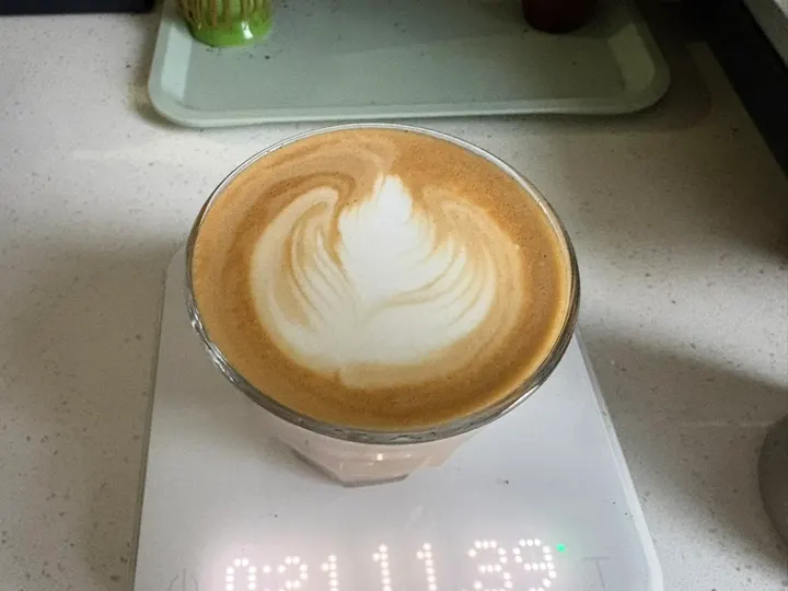 A tulip on a latte resting on a digital scale
