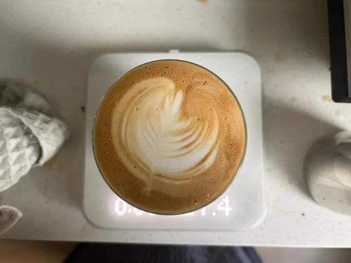 A latte on the scale with a layered tulip