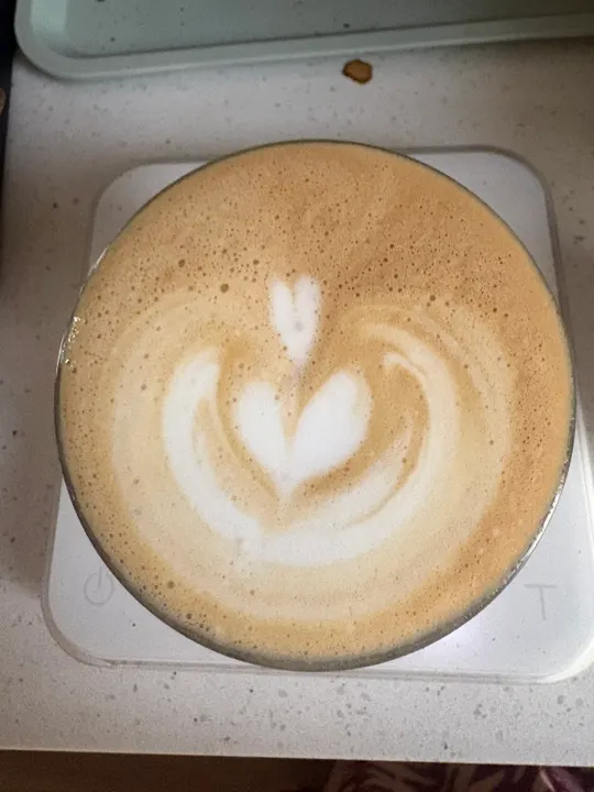 Overhead view of a latte on the scale with a stacked tulip