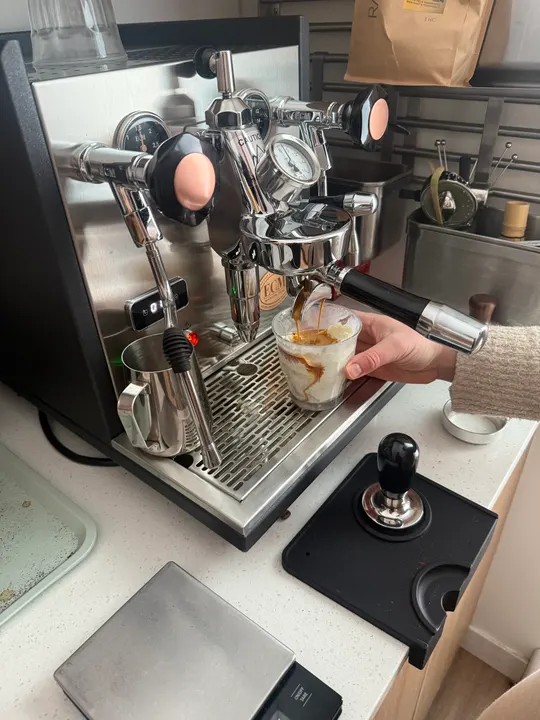 Pulling an espresso shot straight from the machine into a glass holding a scoop of ice cream