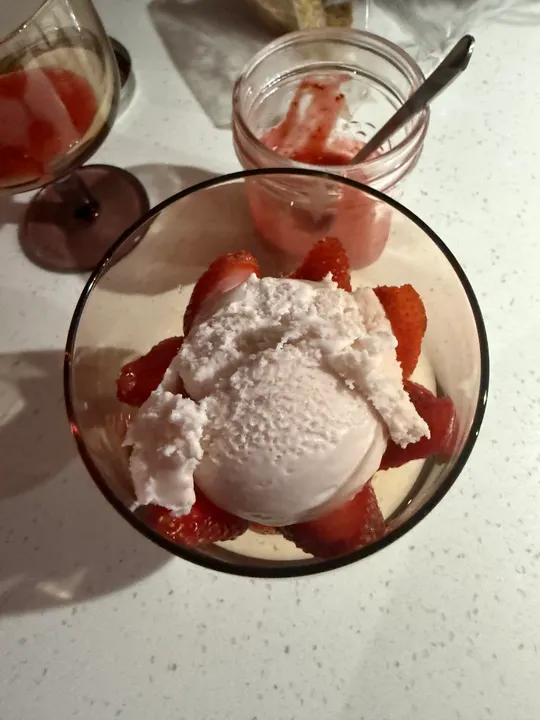 Overhead view of the sundae, a jar of strawberry sauce beside it
