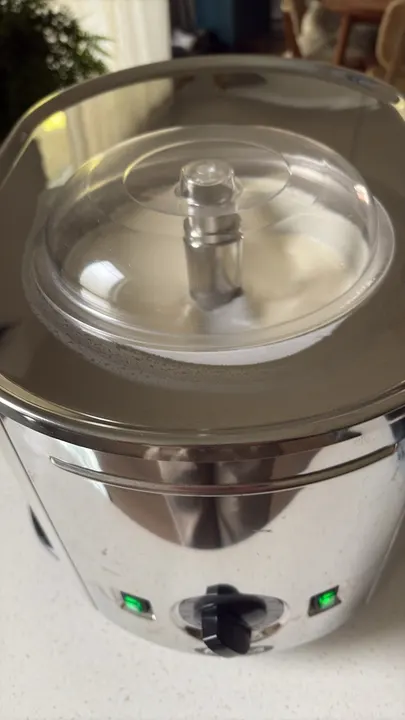 The ice cream machine on the counter: a steel body with a clear domed lid